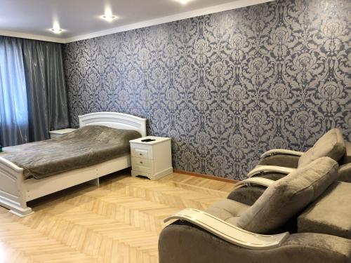 ウラジカフカスにあるОднокомнатная квартираのベッドルーム1室(ベッド2台、ソファ付)
