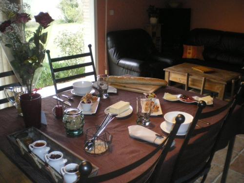 a dining room table with a table cloth and food on it at Le Poulailler in Lavit