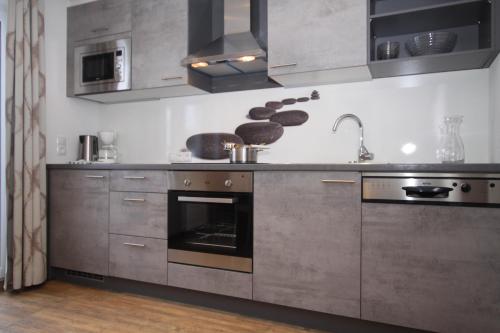 a kitchen with stainless steel cabinets and an oven at Lärchenheim Apartments in Ischgl