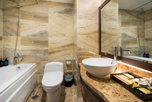 ein Badezimmer mit einem Waschbecken, einem WC und einer Badewanne in der Unterkunft Nhat Ha 2 Hotel in Ho-Chi-Minh-Stadt