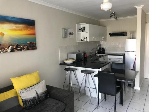 a kitchen with a couch and a kitchen with a counter at 10 South Views in Bloubergstrand