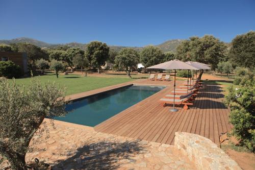 einen Pool mit einer Holzterrasse und einem Sonnenschirm in der Unterkunft Casa Legna in Pigna