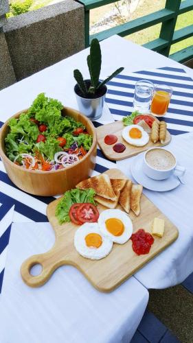 een tafel met eieren, brood en een salade bij Aekpailin River Kwai Resort in Kanchanaburi