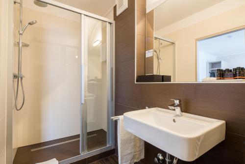 ein Bad mit einem Waschbecken und einer Dusche in der Unterkunft Best Western Hotel Breitbach in Ratingen