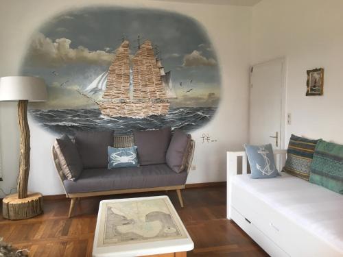 a living room with a couch and a painting on the wall at Hotel Fresena in Baltrum