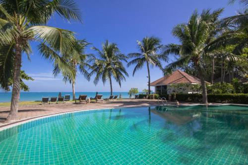 a swimming pool with palm trees and the ocean at Rajapruek Samui Resort - SHA Plus in Lipa Noi