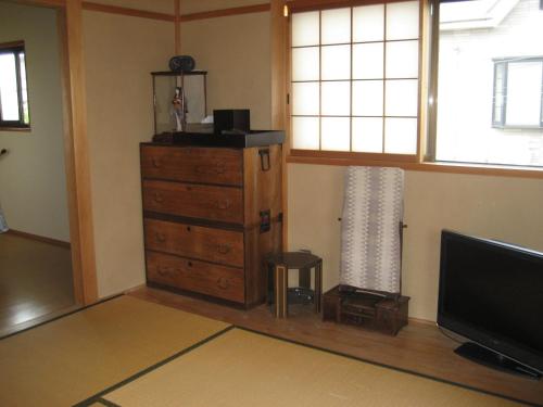 salon z komodą i telewizorem w obiekcie Kyoto Narutaki Keisenso w mieście Kioto