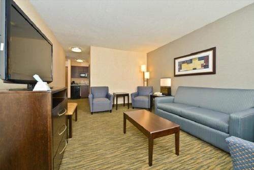 a living room with a couch and a flat screen tv at Best Western Plus Coldwater Hotel in Coldwater