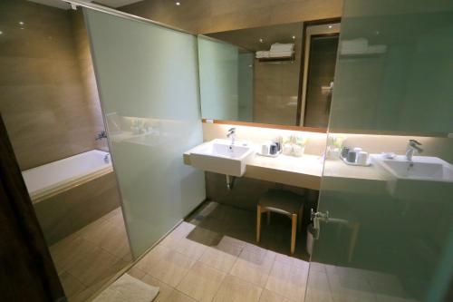 a bathroom with two sinks and a shower at 車站100m民宿丨電梯附停車場 in Hualien City