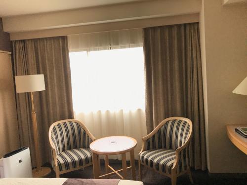 a chair and a table in a room at Numazu River Side Hotel in Numazu
