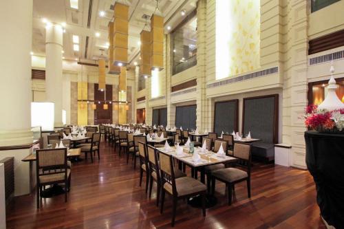 a dining room with tables and chairs in a building at The Imperial Hotel & Convention Centre Korat in Nakhon Ratchasima