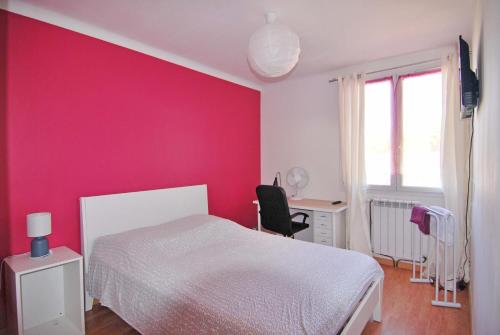 モンペリエにあるChambre Montpellier Campanules (home sharing)のピンクの壁のベッドルーム(ベッド1台、デスク付)