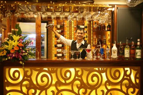 a man standing behind a bar with at Oriental Sails Cruise in Ha Long