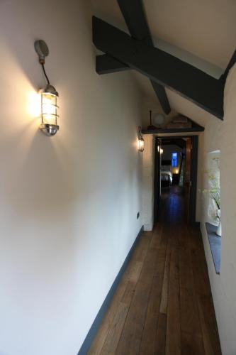 a hallway in a house with lights on the wall at Rod and Line in Landrake