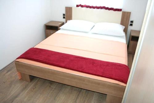 a bed with two pillows on it in a room at Lucija Apartments in Krk