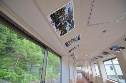 a train hallway with windows and pictures on the walls at Shin Kabakawa Kanko Hotel in Takamatsu