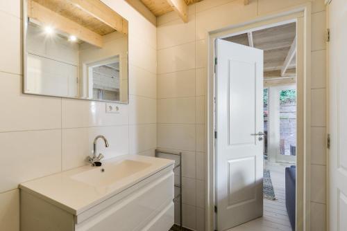 La salle de bains est pourvue d'un lavabo et d'un miroir. dans l'établissement Moyo Kijani, à Zandvoort