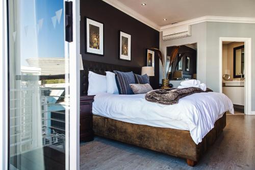 ein Schlafzimmer mit einem großen Bett und einer Glastür in der Unterkunft 512 The Granger in Kapstadt
