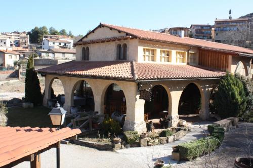une maison avec un toit carrelé dans une cour dans l'établissement Raco del Tosca, à Beceite