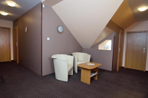 a hospital room with a sloped ceiling and a table at Hotelik Gościniec Pod Sosnami Drzonków in Zielona Góra