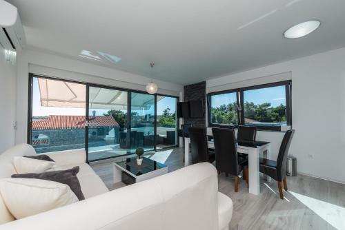 a living room with a white couch and a table at Luxury Apartments VilaMaloca in Vir