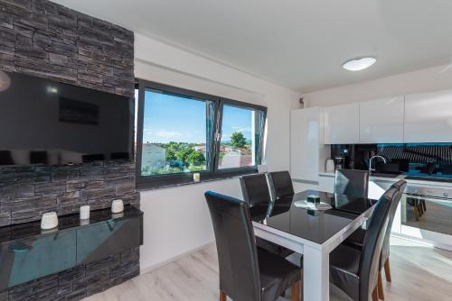 a kitchen and dining room with a table and chairs at Luxury Apartments VilaMaloca in Vir
