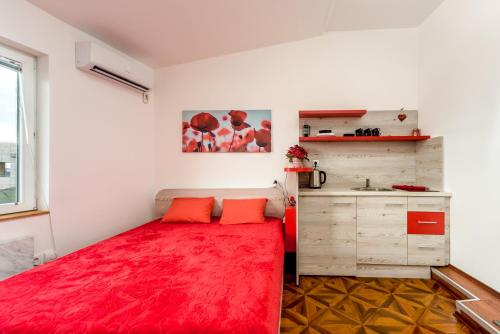 una camera da letto con un letto rosso e una cucina di Lux Apartment in Downtown a Belgrado