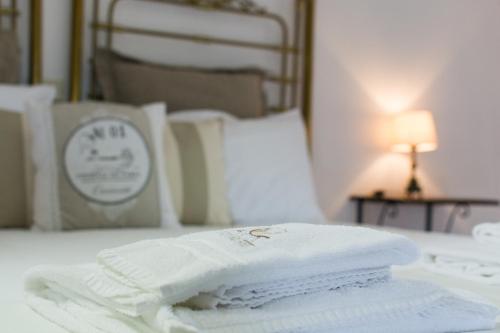 a stack of white towels sitting on a bed at Castello di Serragiumenta in Firmo