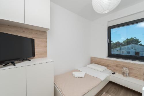 a white living room with a tv and a window at Luxury Apartments VilaMaloca in Vir