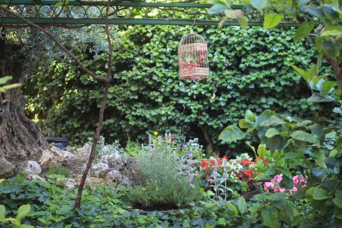 a garden with flowers and a bird cage at Felicin - Ristorante Albergo "Dimora Storica" in Monforte dʼAlba