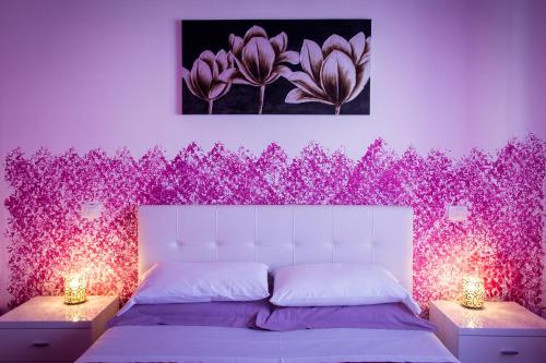 a bedroom with a purple wall with pink flowers at Colors B&B in Palermo