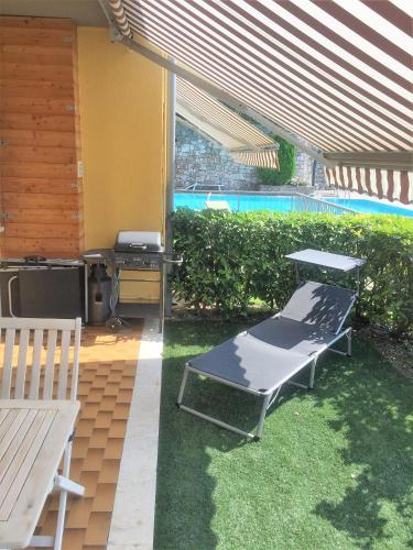 eine Terrasse mit Tisch, Bank und Grill in der Unterkunft Sander House in Malcesine