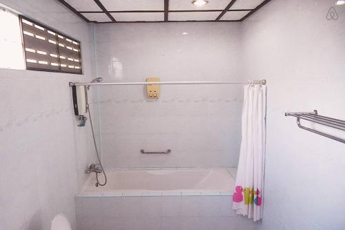 ein Bad mit Dusche und Duschvorhang in der Unterkunft Thai Muang Resort in Thai Muang