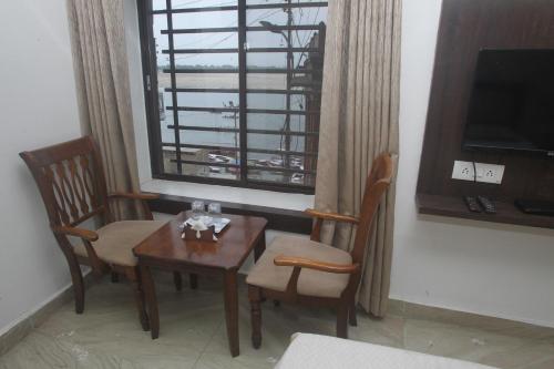 une chambre avec une table, des chaises et une fenêtre dans l'établissement Alakhnanda Guest House, à Varanasi
