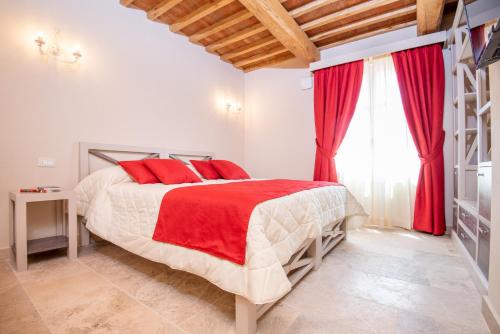 a bedroom with a large bed with red pillows at Relais dei Molini - Villa dei Molini in Castagneto Carducci