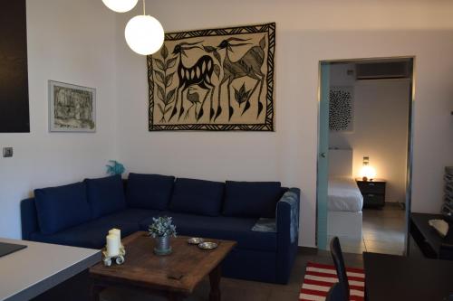 a living room with a blue couch and a table at CLIO'S BEACH HOUSE - DELUXE BEACH FRONT PROPERTY in Órmos