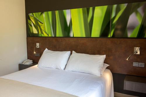 a bedroom with a bed with a large painting on the wall at Mayfair Gardens in Paphos City
