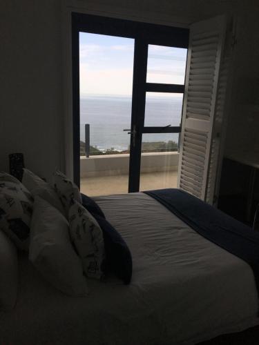 1 dormitorio con cama y vistas al océano en Tranquillo en Mossel Bay
