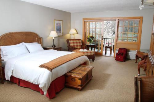 グランツパスにあるThe Lodge at Riversideのベッドルーム(大型ベッド1台、椅子付)