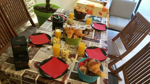 ein Tisch mit Brot, Flaschen mit Orangensaft und Kerzen. in der Unterkunft Chez Laurence in Santenay