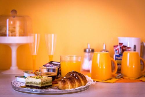 a table with a plate of bread and orange juice at Colors B&B in Palermo