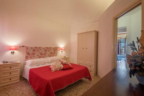 a bedroom with a red bed with a red blanket at Casa Scilocco in San Vito lo Capo