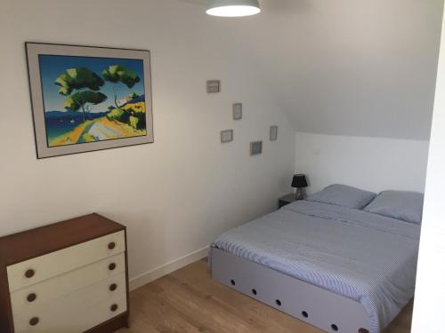 サン・ケ・ポルトリユーにあるMaison de charme kertugalのベッドルーム1室(ベッド1台付)が備わります。壁には絵画が飾られています。