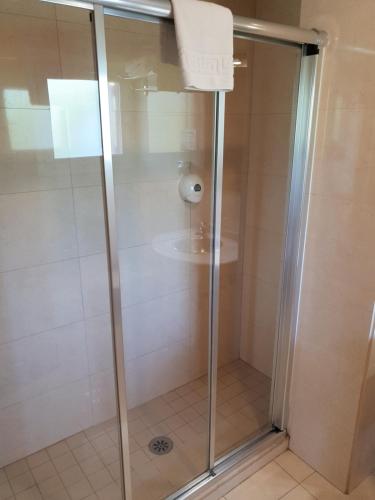 a shower with a glass door in a bathroom at Hotel Spa Pinar del Mar in Platja  d'Aro