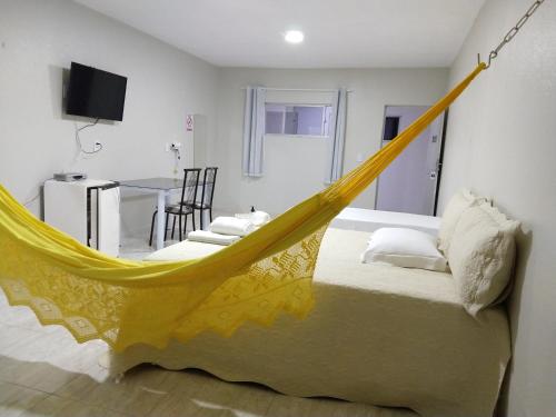 een bed met een gele hangmat in een kamer bij Confiance Hotel in Crateús