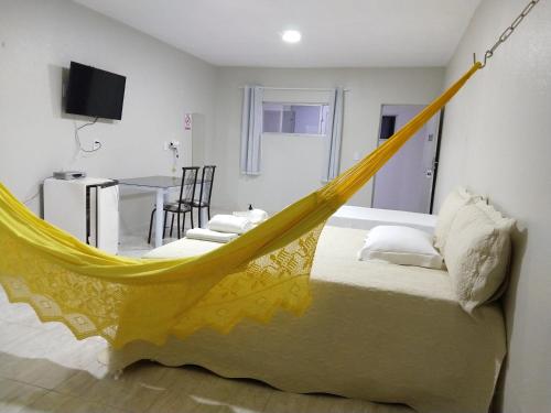 a bed with a yellow hammock in a room at Confiance Hotel in Crateús