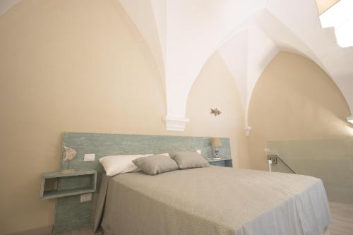 a bedroom with a bed in a white room at Il Giardino Della Regina in Gallipoli