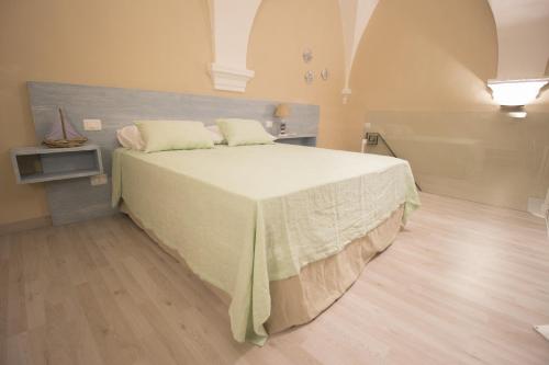 a bedroom with a large bed with a white blanket at Il Giardino Della Regina in Gallipoli