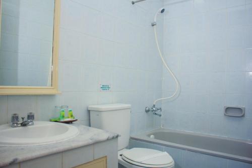 a bathroom with a toilet and a sink and a shower at Sapta Nawa Resort 1 Gresik in Gresik