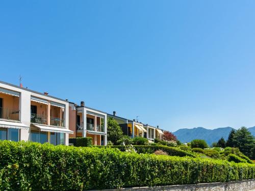 uma fila de casas com arbustos e montanhas ao fundo em Belvilla by OYO Cielo d Italia em Verbania
